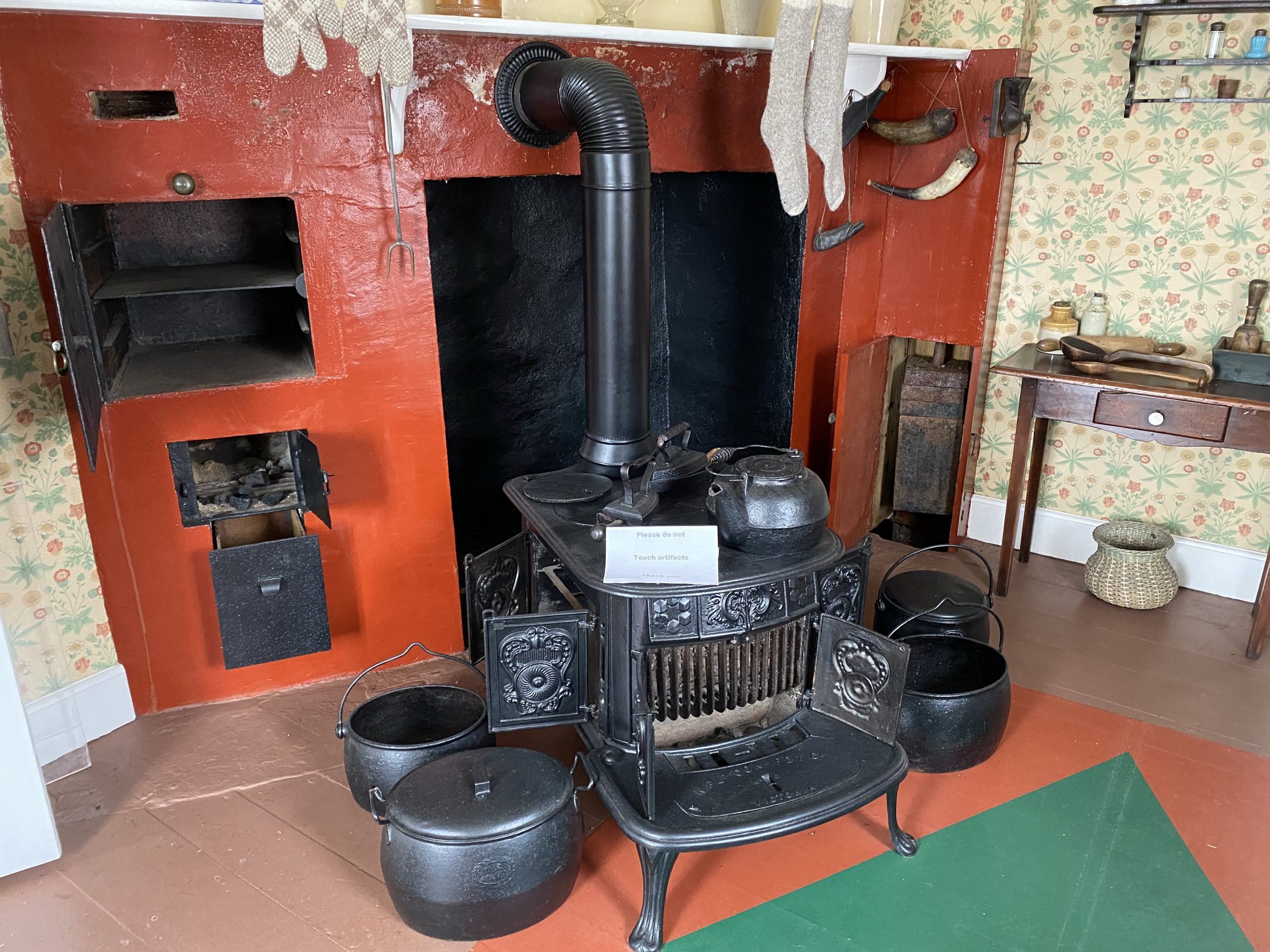The cooking/heating stove and hearth in the Bonavista lighthouse; you can see the lighthouse counterweight in the open right side door.
