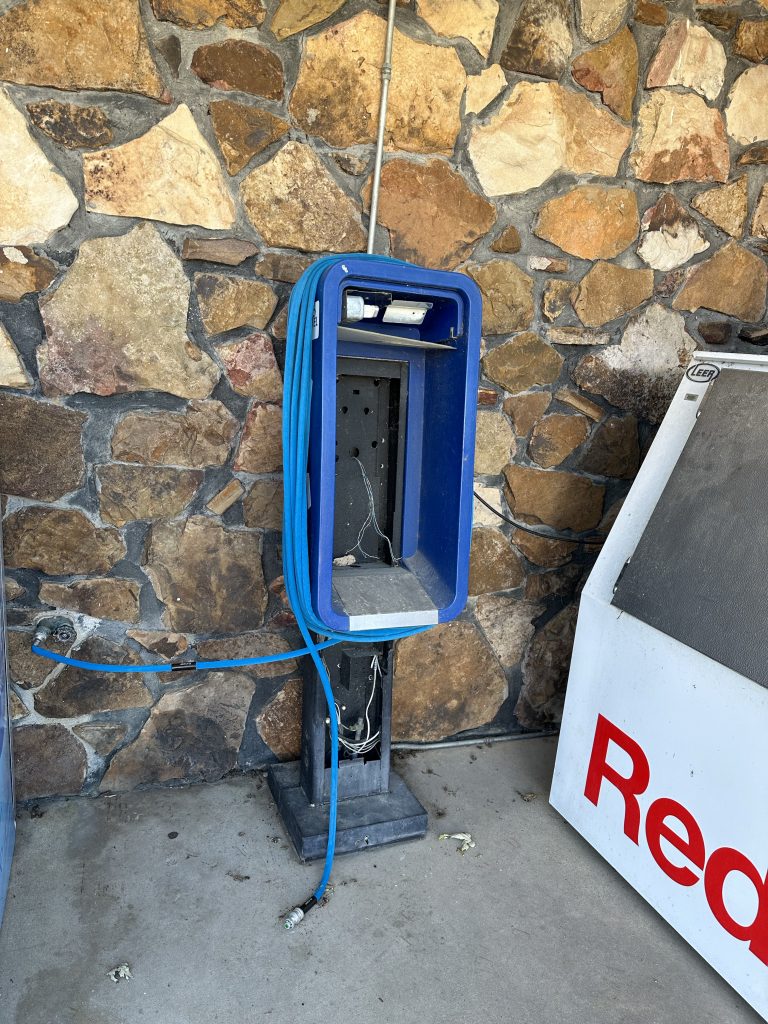 An old phone booth repurposed as a hose reel; at a convenience store in Success, AR.