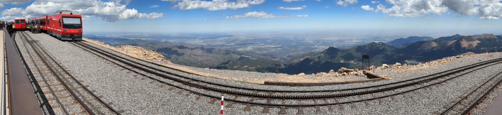 A panoramic view of the two cog railway trains (old and new) waiting at the top of Pike’s Peak.