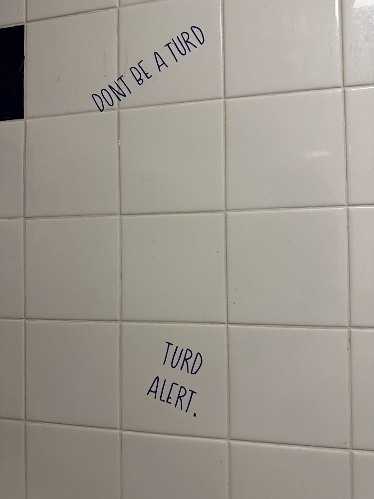 Humorous wall graffiti in a gas station restroom in Seney, Michigan.