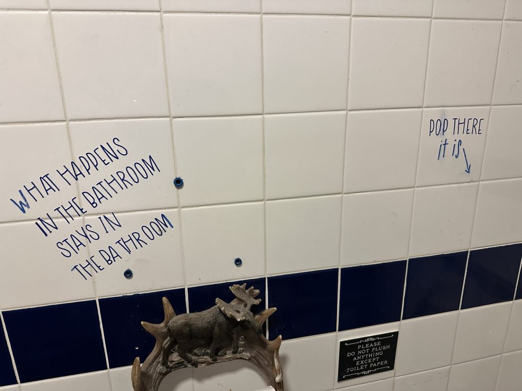 Humorous wall graffiti in a gas station restroom in Seney, Michigan.