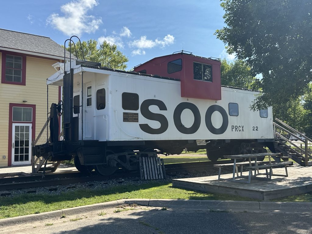 An old Soo Line caboose in front of the old freight house in Remer, Minnesota.