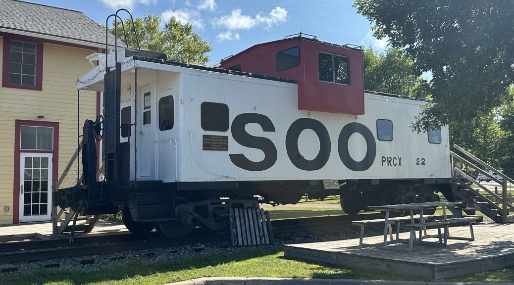 An old Soo Line caboose in front of the old freight house in Remer, Minnesota.